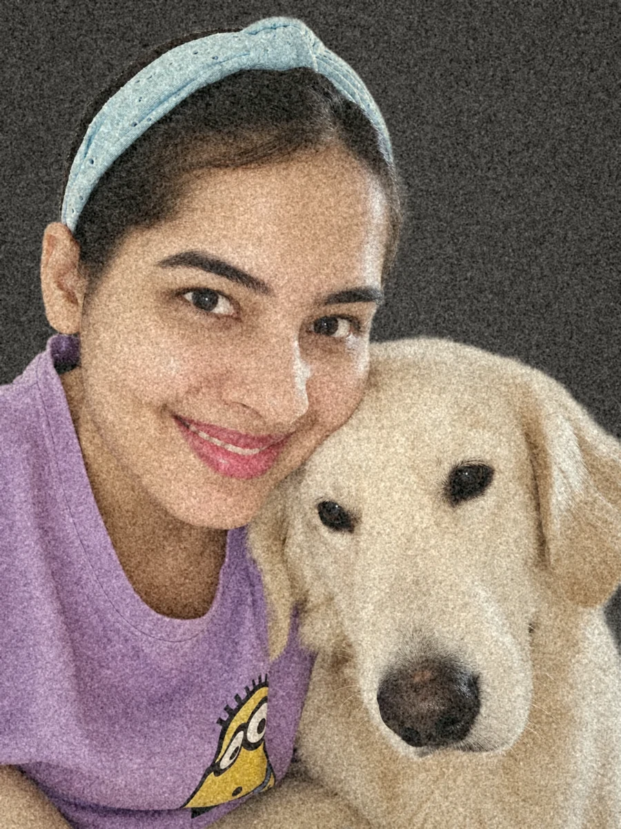 Gayathri smiling, cheek to cheek with her English cream retriever